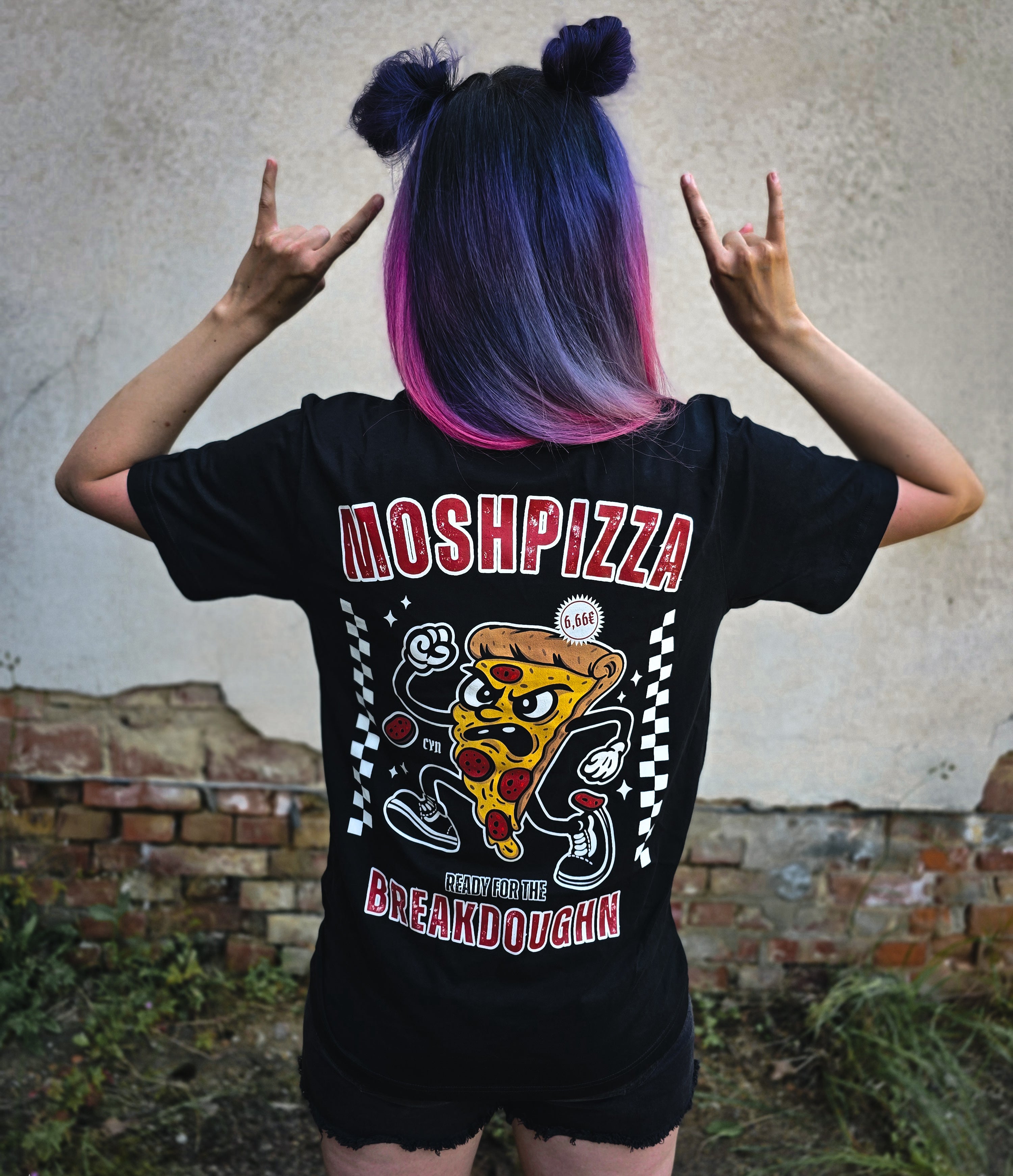 Moshpizza T-Shirt mit moshender Comic-Pizza-Motiv – getragen von Frau mit bunten Haaren – Alternative Streetwear für die Metalcore-Szene