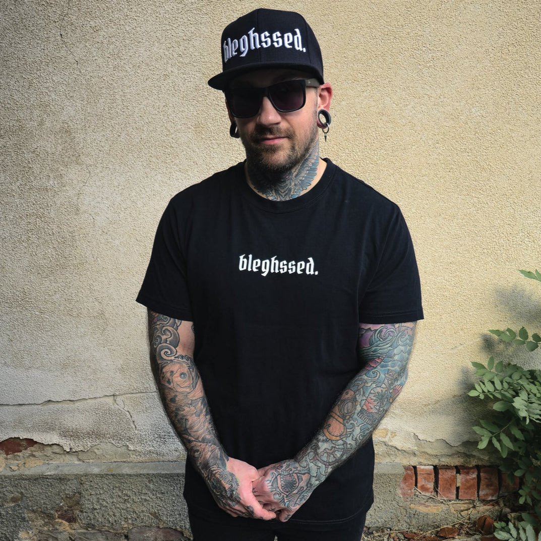 Schwarze Cap mit weißer 3D-Stickerei des Schriftzugs ‚bleghssed‘ auf der Vorderseite