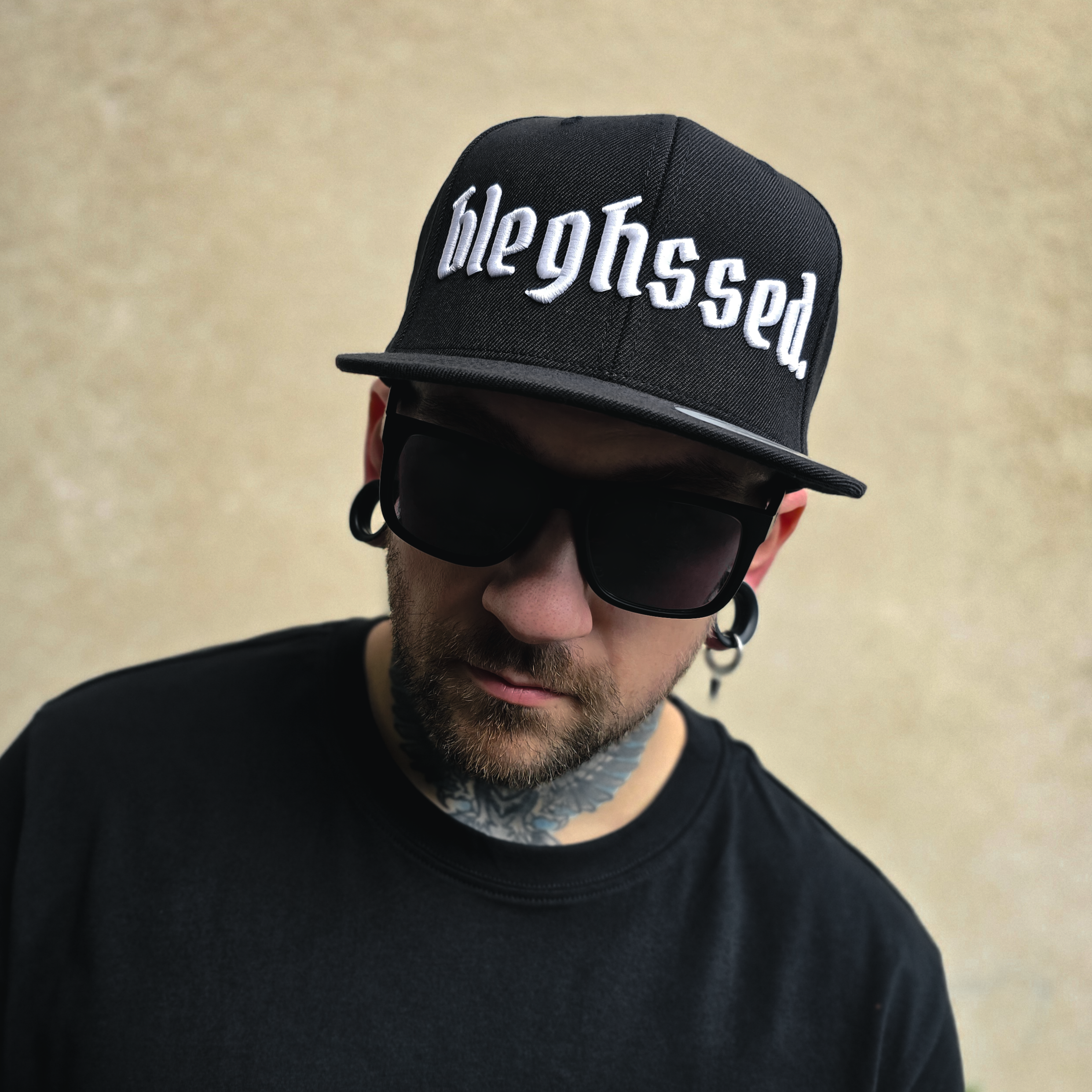 Schwarze Cap mit weißer 3D-Stickerei des Schriftzugs ‚bleghssed‘ auf der Vorderseite
